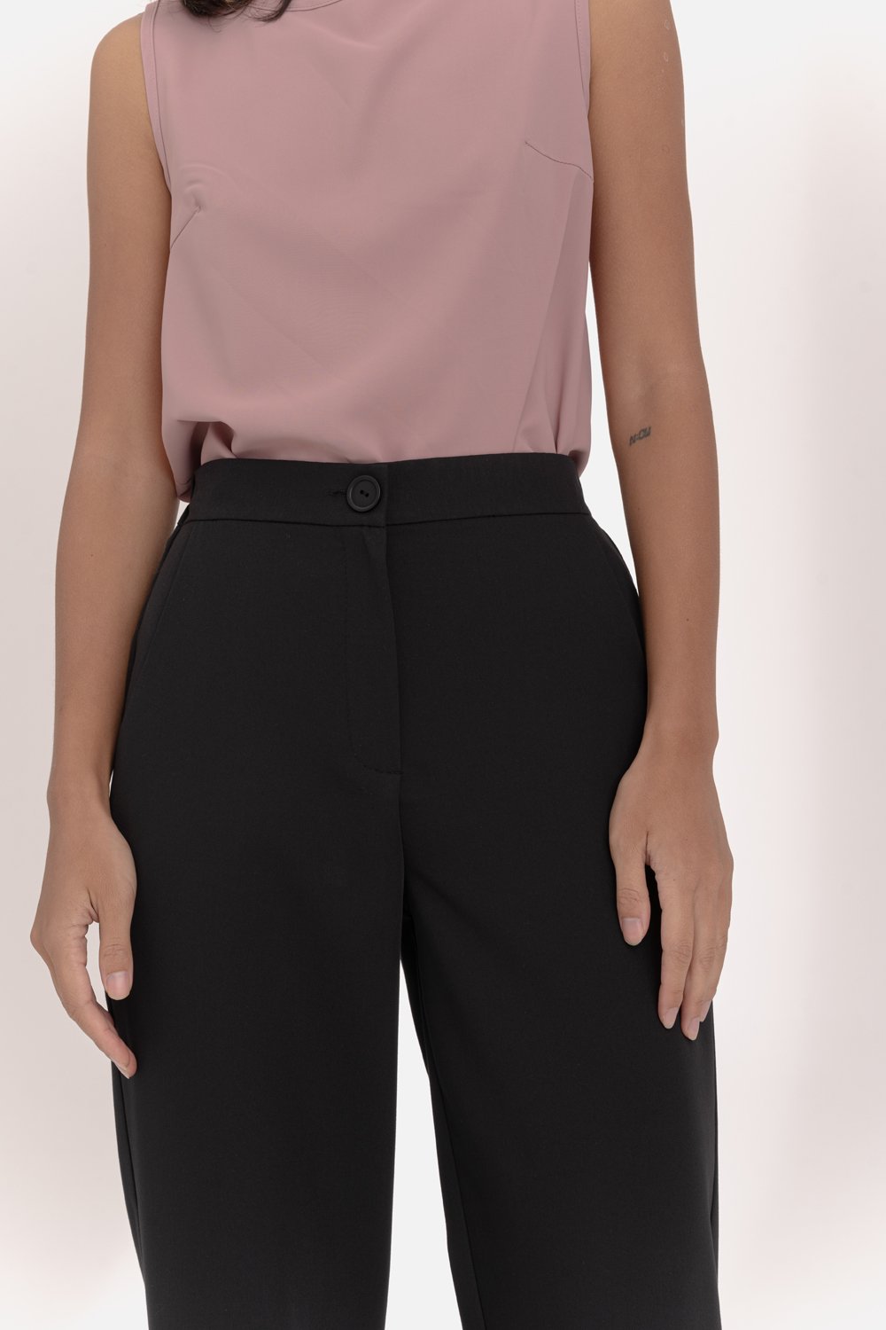 Black trousers with an elasticated waistband and pleats at the hem