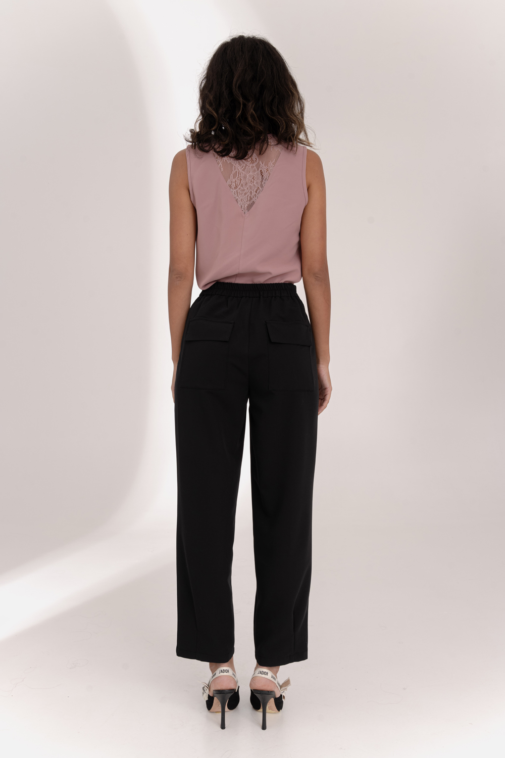 Black trousers with an elasticated waistband and pleats at the hem