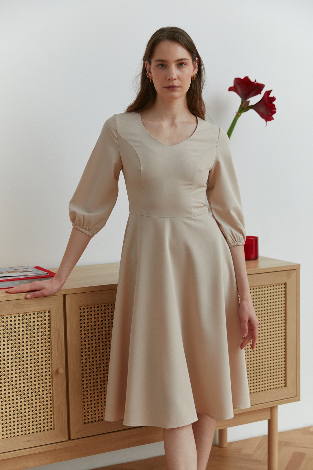 Бежева сукня довжини міді з V-подібним вирізом горловини та рельєфним ліфом