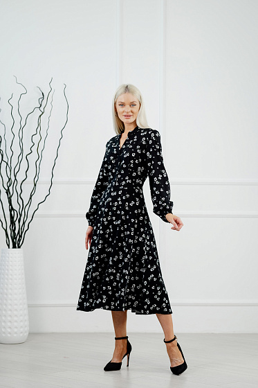 Сукня приталеного крою для романтичного настрою. Спідниця кльош та довжина міді. Комір стійка з V-подібною горловиною та застібкою на гудзики на фігурній, відрізній планці. Підкреслять образ довгі рукави ліхтарики.