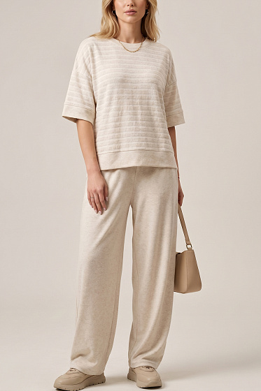 Стильный женский костюм в стиле minimal chic: свободная полосатая футболка с V-образным вырезом и брюки-бананы на резинке. Продуманный крой визуально вытягивает силуэт и создаёт расслабленный элегантный образ без перегруженности. Идеальный комплект для города, путешествий и повседневного гардероба.