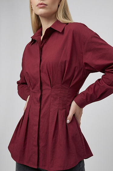 Елегантна блуза напівприталеного крою з довгими рукавами на ґудзиках та коміром стійка-ворот. Застрочені складки на лінії талії формують витончений силует. Ідеальний варіант для офісу та стильних щоденних образів. Лаконічний дизайн легко поєднується з спідницями та брюками.