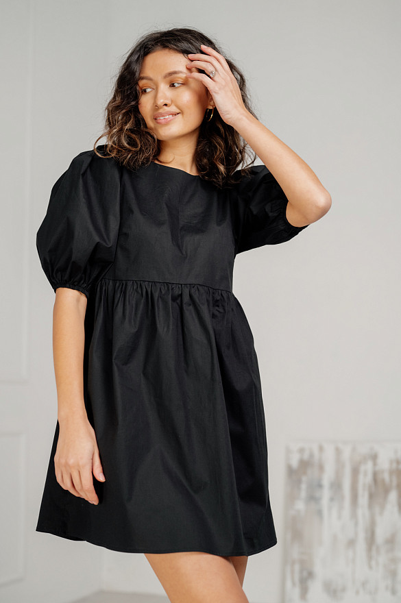 Black cotton mini dress with loose skirt.
