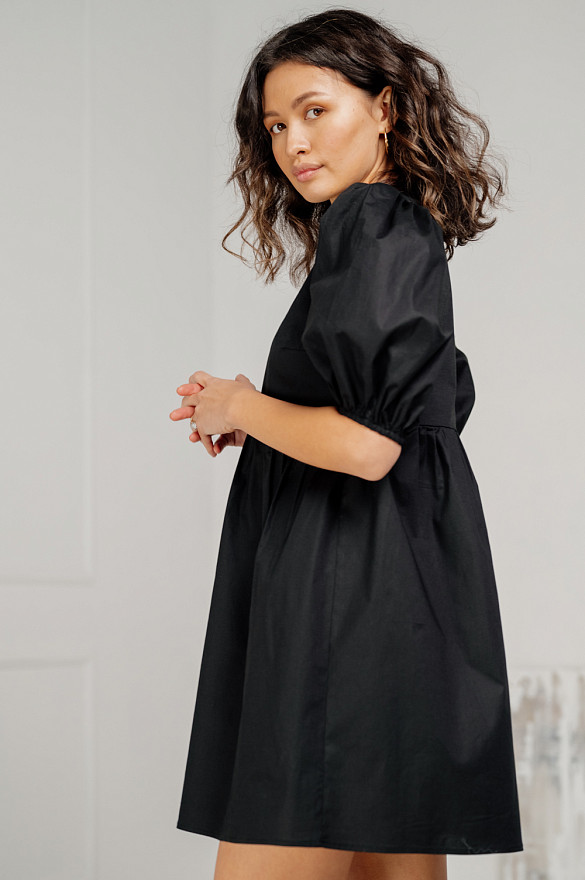 Black cotton mini dress with loose skirt.