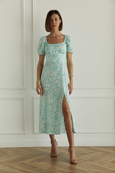 An elegant fitted dress with an elastic back for a comfortable fit. There is a gather at the chest that creates a sophisticated accent. The puffed sleeves with elastic give volume, and the a-line skirt with a slit adds femininity and lightness. An ideal choice for a stylish look.