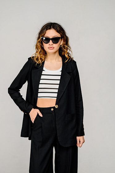 Льняной пиджак свободного кроя, воротник лацкан, спереди два больших кармана, подплечники, застегивается на пуговицу. В коллекции есть брюки в тон к пиджаку.