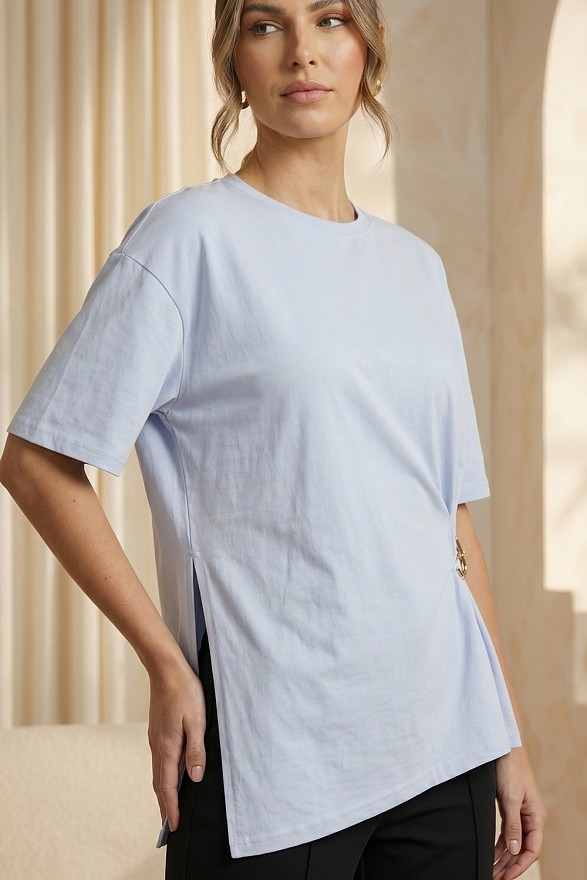 Light blue asymmetrical loose T-shirt with a slit and a brooch