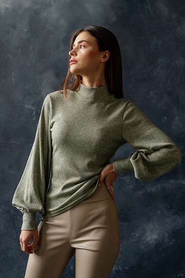 Мягкий гольф из трикотажа с горловиной и рукавами-манжетами.