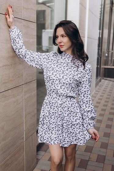 A light and airy mini dress with a double fluffy skirt will create a romantic look. An original detail is a ruffle on the neck with a tie on the back. The waist is emphasized with an elastic band and belt, providing a perfect fit. Loose long sleeves with elastic cuffs add comfort. A universal model for stylish looks for every day and special occasions.